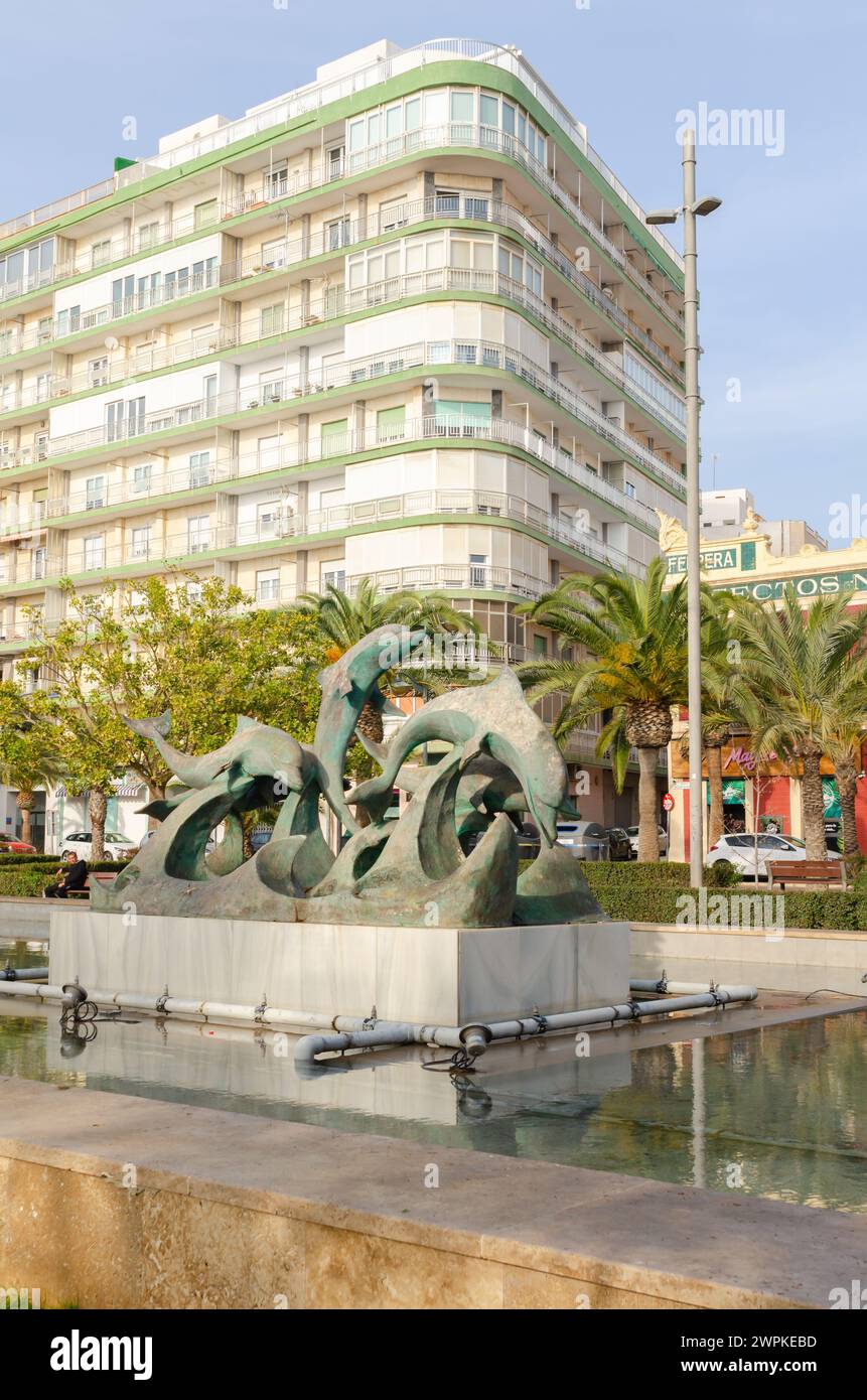 ALMERIA, ESPAGNE - 11 DÉCEMBRE 2023 la sculpture représente cinq beaux dauphins jouant sur les vagues, au centre d'une fontaine rectangulaire Banque D'Images