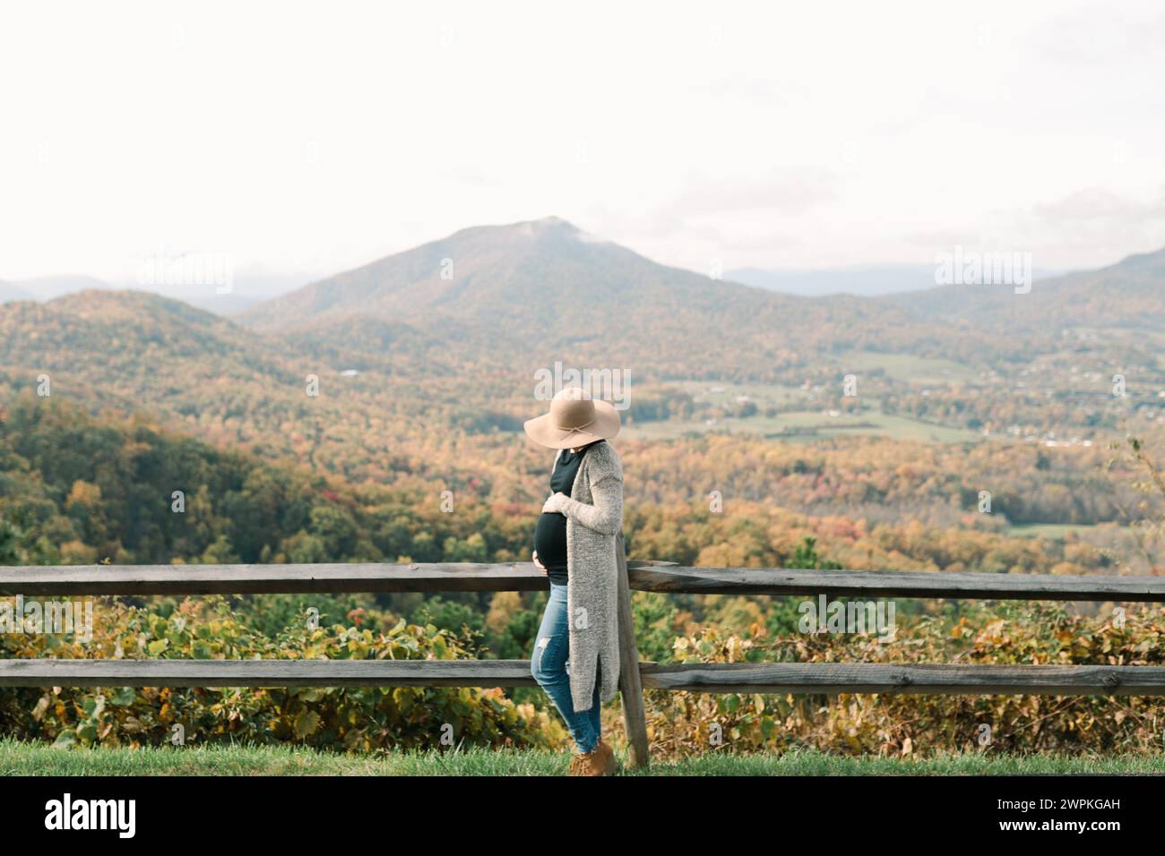 Mère enceinte tenant le ventre surplombant les montagnes à l'automne Banque D'Images