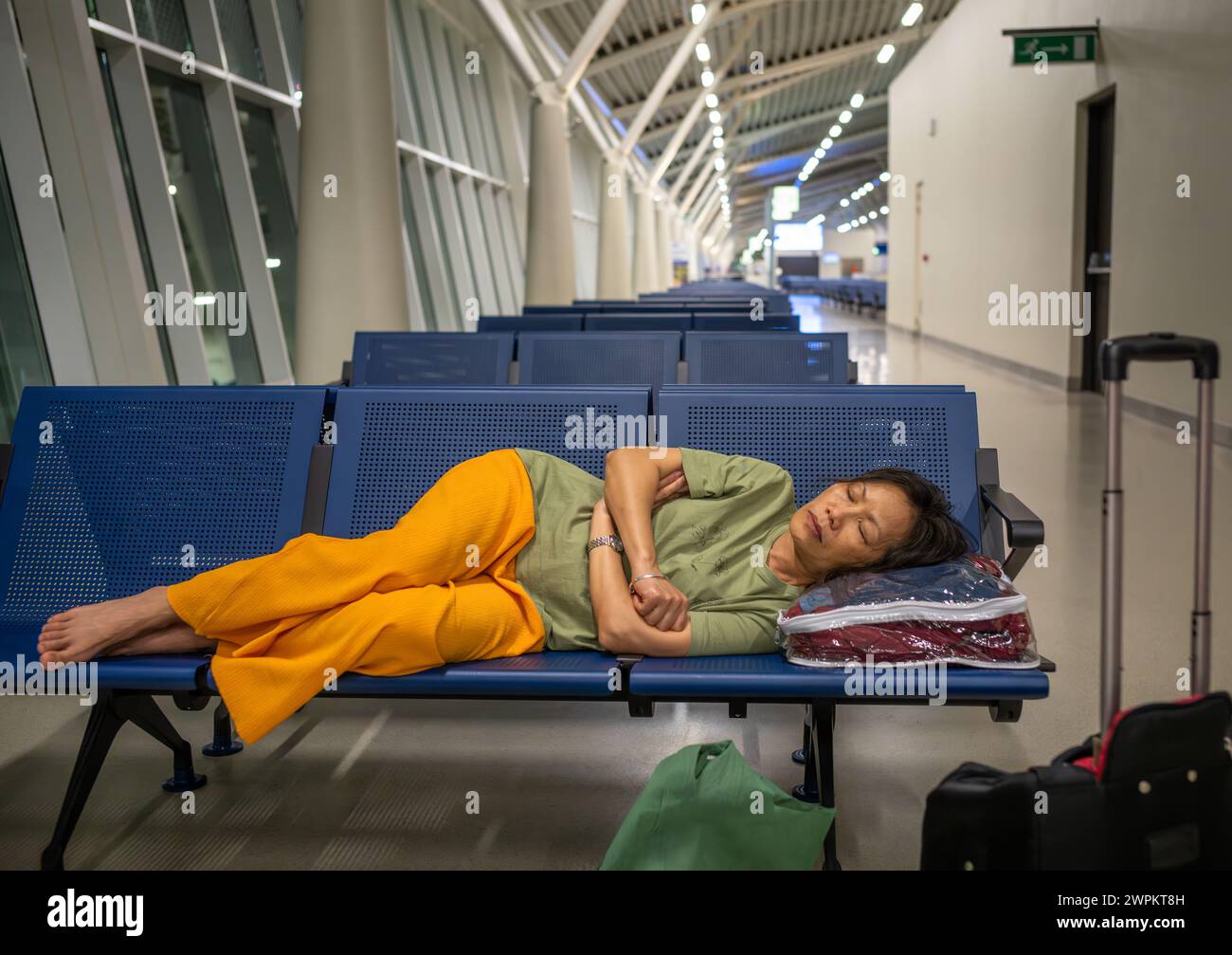 Une passager dort avant son vol au terminal 3 de l'aéroport international Julius Nyerere, Dar es Salaam, Tanzanie Banque D'Images