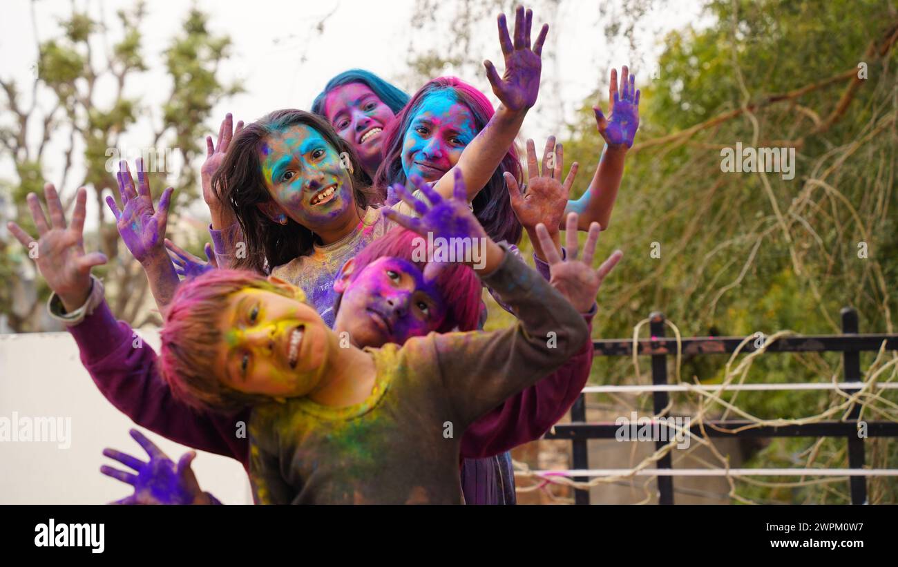 Joyeux petits enfants indiens souriants montrant leurs mains colorées ou l'impression de paume ou jouant au festival holi avec des couleurs Banque D'Images