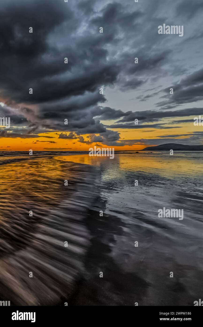 Coucher de soleil de Sandy Gap sur Walney Island, vue vers la lointaine Combe Noire à travers la mer d'Irlande, l'estuaire de Duddon et la côte Cumbrian, Cumbria Banque D'Images