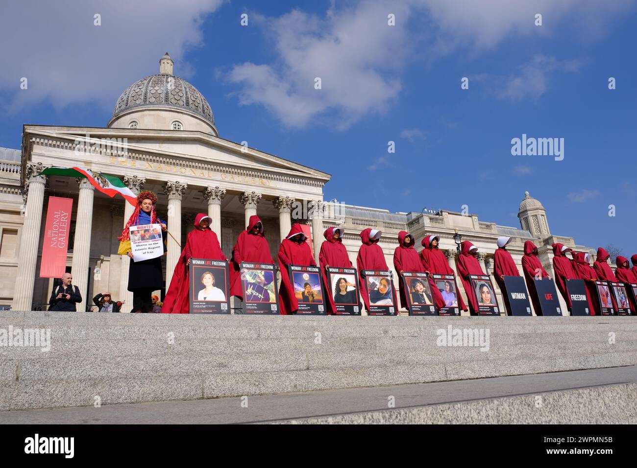 Londres, Royaume-Uni, 8 mars 2024. Des femmes vêtues de servantes racontent des costumes qui défilent dans le centre de Londres à l'occasion de la Journée internationale de la femme pour exiger des améliorations dans les droits et libertés de ceux qui vivent sous le régime islamique en Iran. Des manifestations ont secoué la nation après la mort de la kurde Mahsa Jina Amini en garde à vue. Crédit : onzième heure photographie/Alamy Live News Banque D'Images