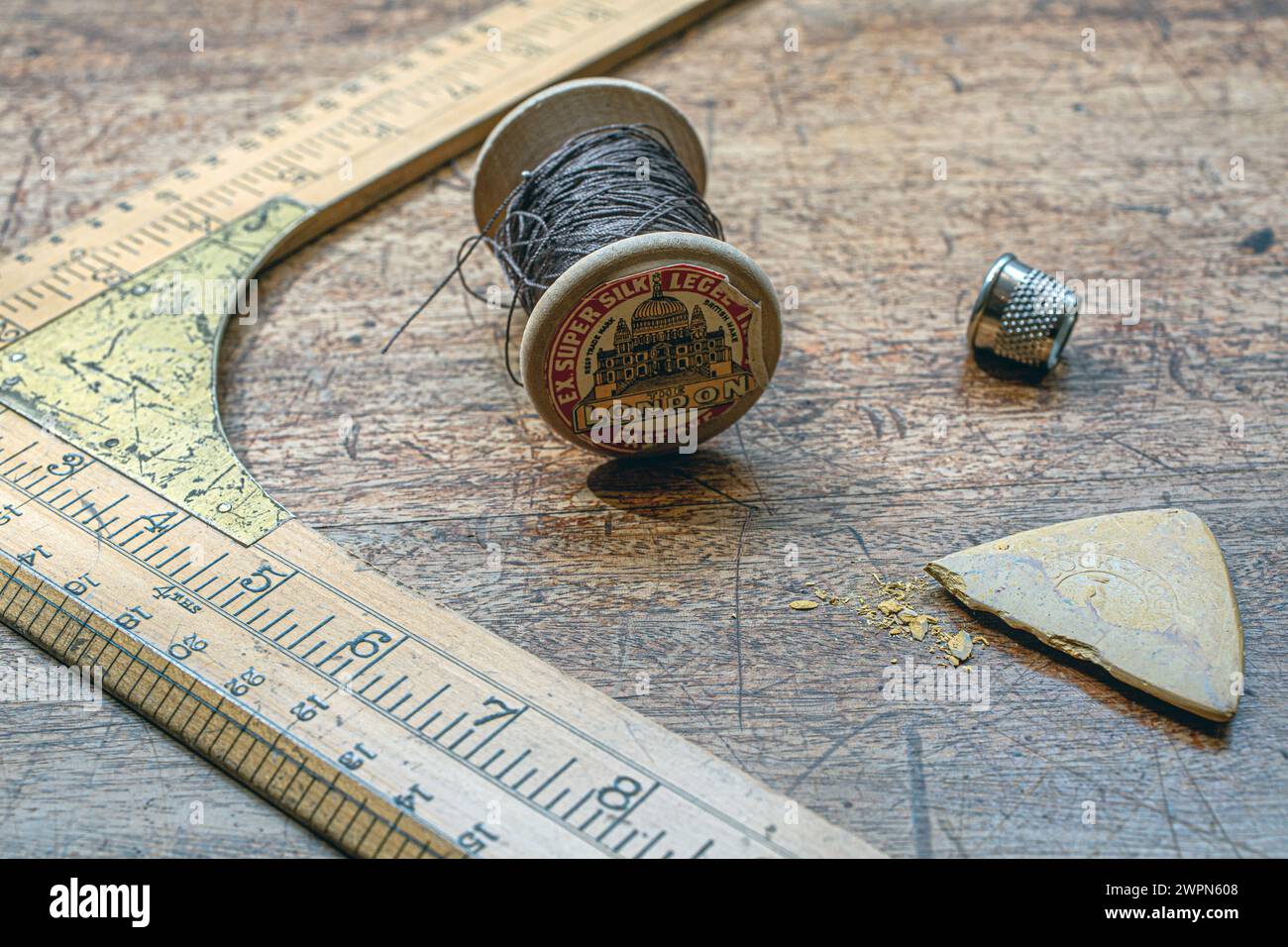 Règle Vintage du tailleur en bois avec une bobine de fil et des dés sur tabel en bois Banque D'Images