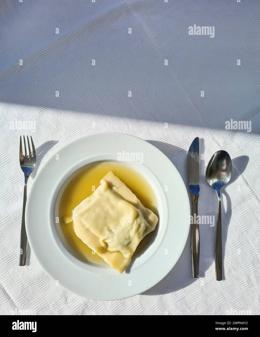 Spécialité - carrés de pâtes souabes dans un bouillon de légumes servis comme repas chaud dans une assiette à soupe profonde Banque D'Images
