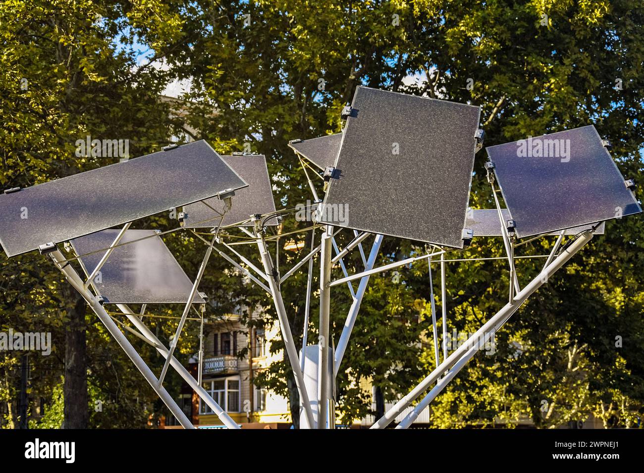 Panneaux solaires montés en forme d'arbre décoratif. Décoration fonctionnelle de rue. Technologie moderne pour charger des gadgets. Vue de dessous, contre le vert Banque D'Images