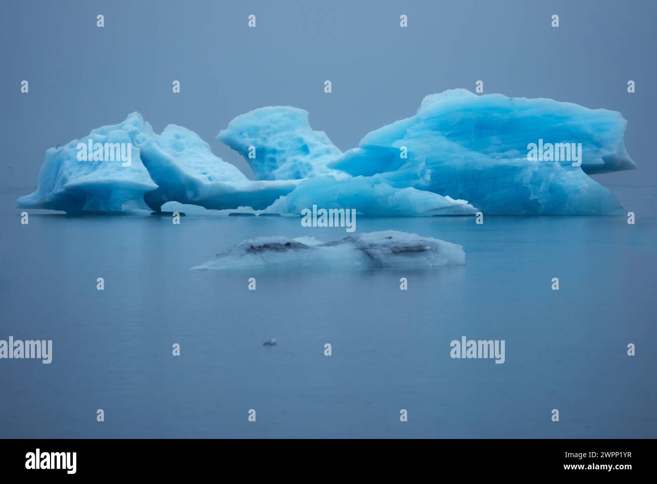 Icebergs bleus chatoyants par jour de pluie sur le lac glaciaire Joekulsarlon. Banque D'Images