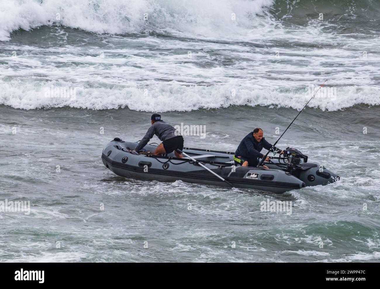 Deux hommes bravent la mer agitée pour aller pêcher dans un bateau gonflable. Océan Pacifique, au large des côtes du Chili. Banque D'Images