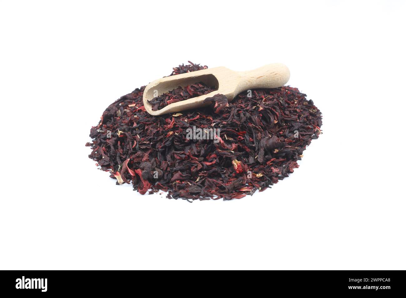 Thé karkade. Feuilles de thé d'hibiscus dans une cuillère en bois isolé sur fond blanc. Le fichier contient un chemin de détourage. Vue de dessus. Banque D'Images