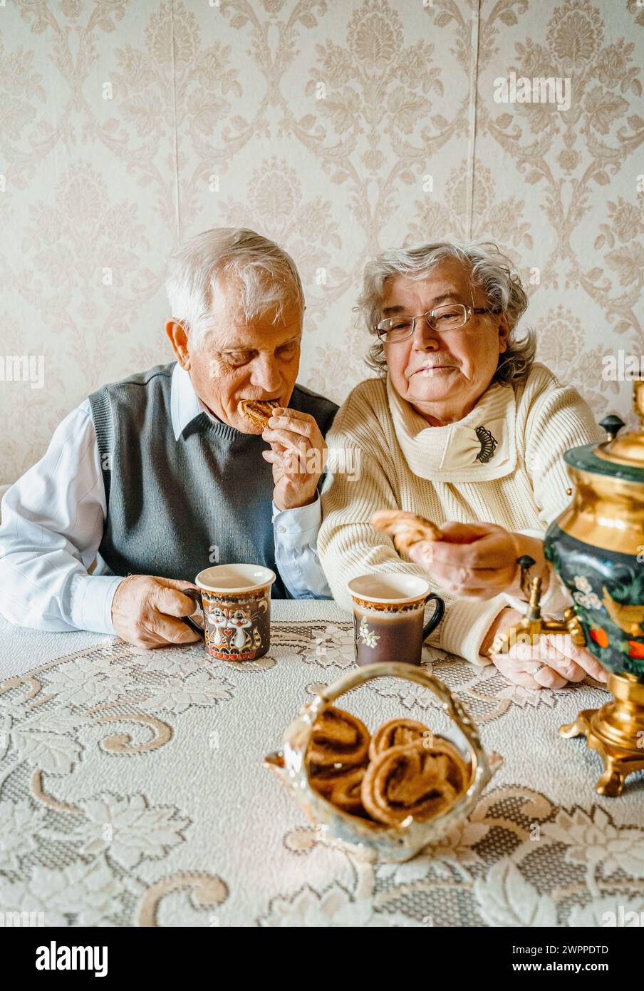 Couple d'amour romantique senior âgé buvant du thé avec des biscuits de samovar. Vieil homme retraité femme ensemble. Vieux mari femme dans la maison confortable. Elder Peop Banque D'Images