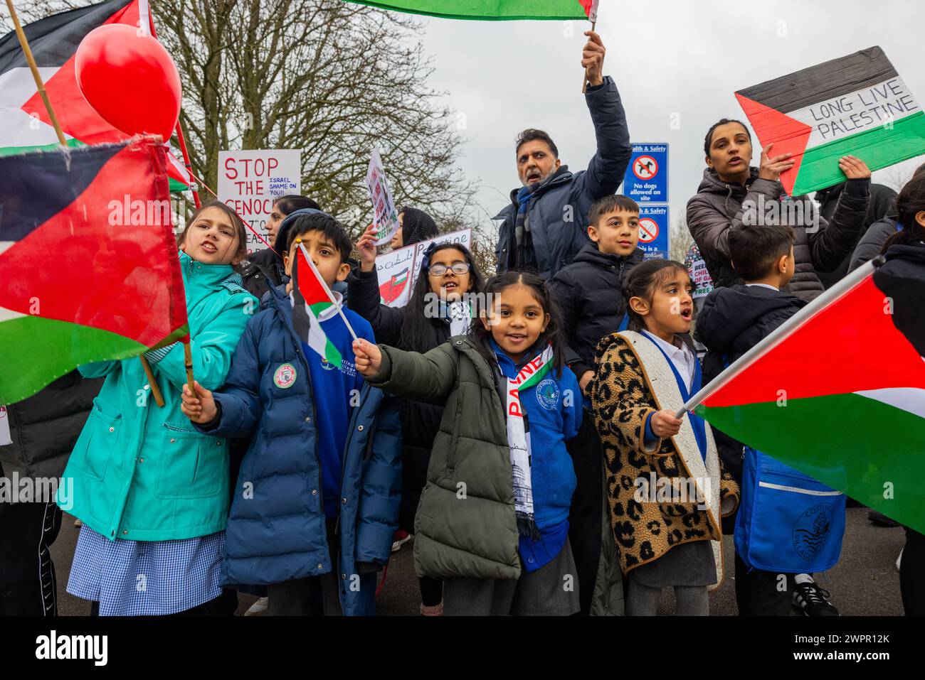 Bingley, Royaume-Uni. 08 MAR, 2024. Étudiants à Cottingley village drapeaux de vague primaire devant les portes principales.. Histoire : les parents d’élèves de l’école primaire Cottingley Village ont sorti leurs enfants à 14h le 8 mars dans le cadre d’un effort de grève coordonné dans plusieurs écoles différentes à travers le Yorkshire pour la Palestine. Crédit Milo Chandler/Alamy Live News Banque D'Images