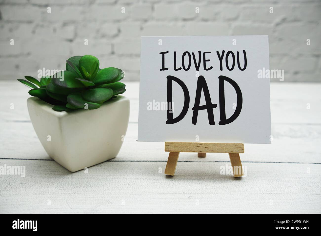 Je t'aime PAPA texte sur chevalet en bois debout sur mur de briques blanches et fond en bois Banque D'Images