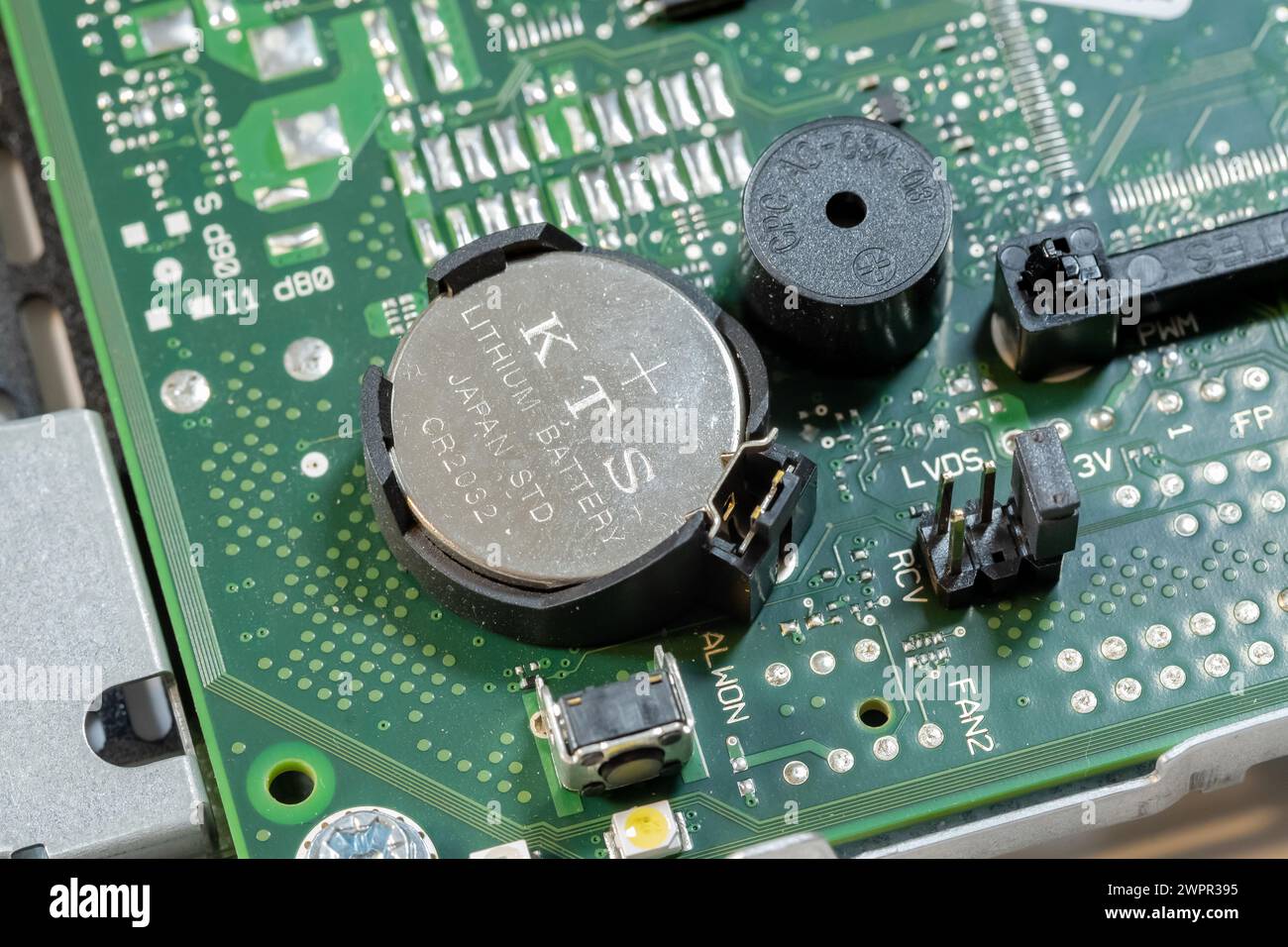 Gros plan détaillé d'une batterie CMOS installée sur une carte mère d'ordinateur, alimentation mémoire BIOS. Changer, remplacer le concept abstrait de cellule, personne Banque D'Images