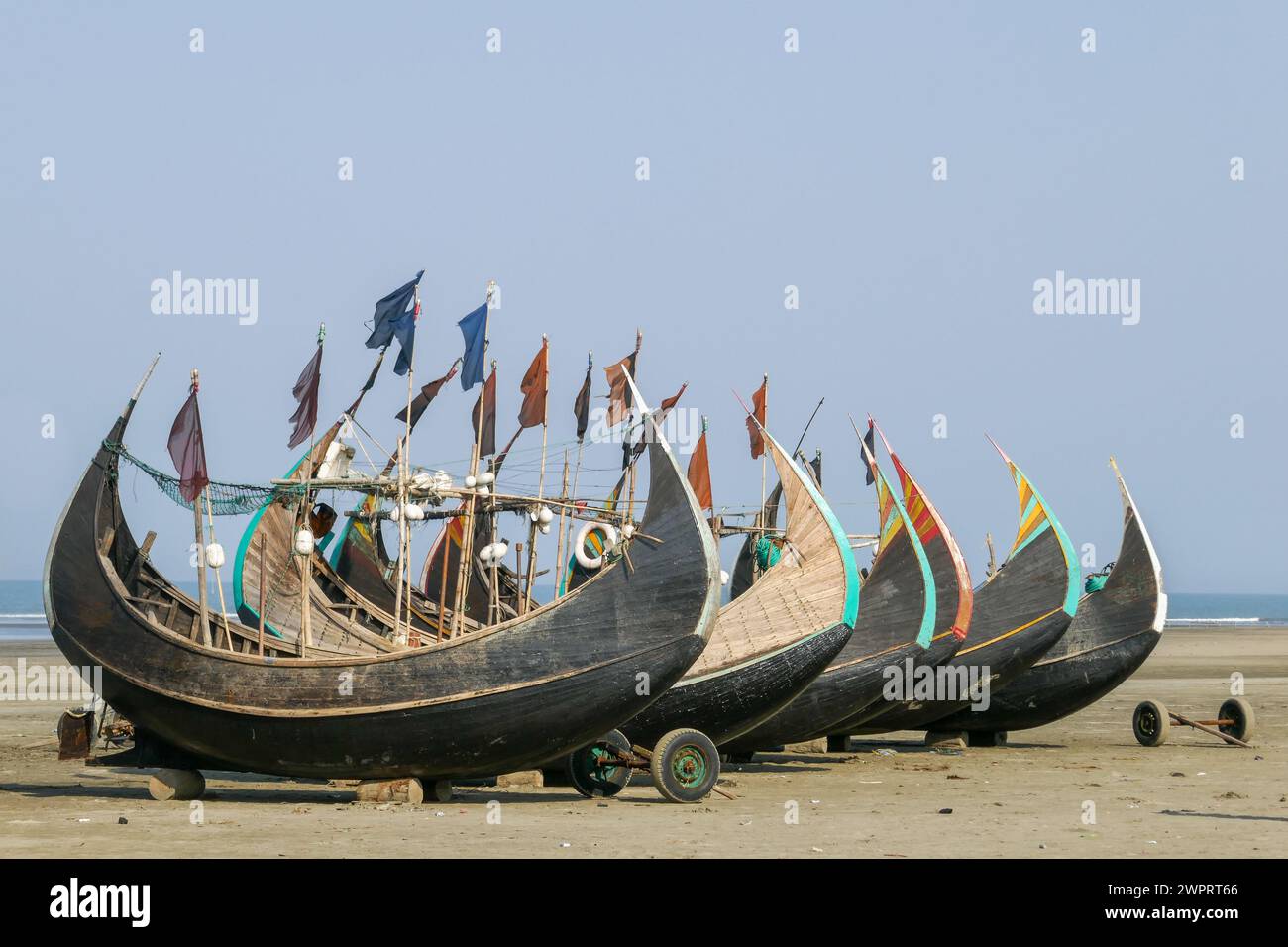 Bateaux de pêche traditionnels colorés en bois connus sous le nom de bateaux lunaires reposant à sec sur la plage d'Inani, Cox's Bazar, Bangladesh Banque D'Images