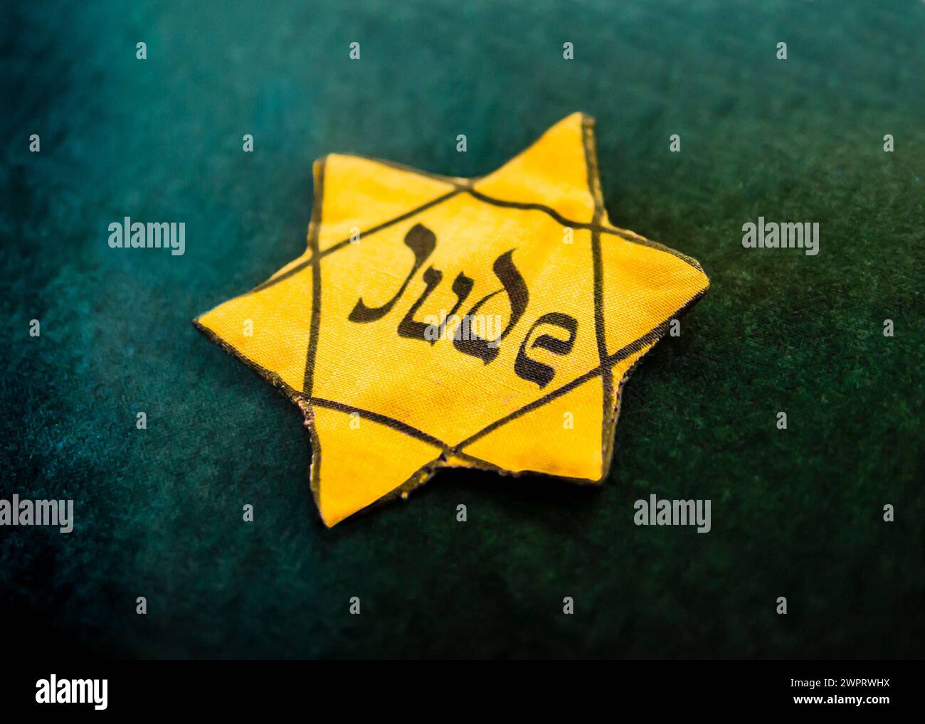 Étoile jaune de David encadrée en noir avec le mot allemand pour «Juif» écrit en style hébreu sur toile, utilisé par les nazis pendant l'Holocauste à ide Banque D'Images