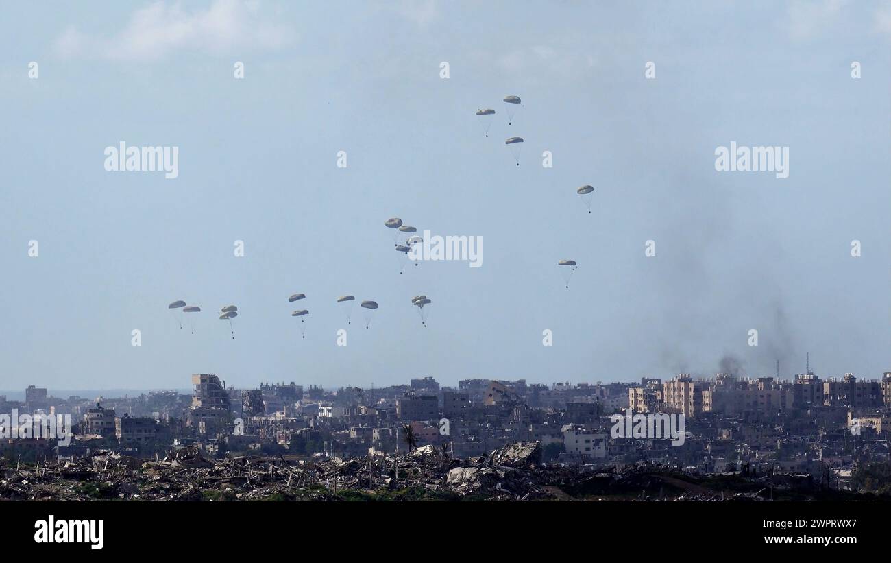 Des parachutes de l'armée américaine larguent des fournitures humanitaires dans le nord de la bande de Gaza, au milieu du conflit en cours entre Israël et le groupe palestinien Hamas. Le 7 mars 2024 à la frontière de Gaza, Sud d'Israël. Banque D'Images