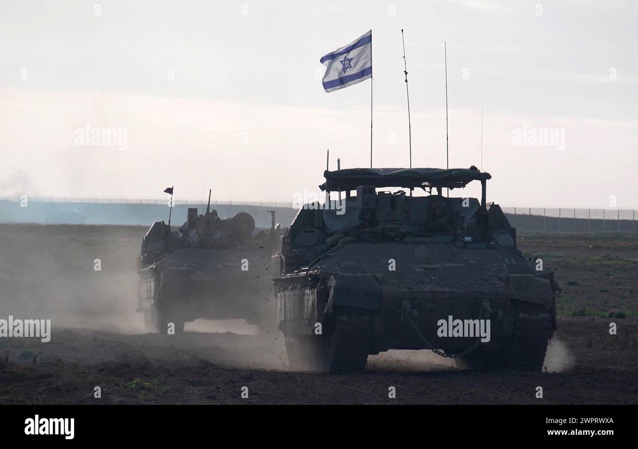 Les véhicules blindés militaires israéliens reviennent du centre de Gaza au milieu des combats qui se poursuivent entre Israël et le groupe militant Hamas le 7 mars 2024 à la frontière de Gaza, dans le sud d'Israël. Banque D'Images