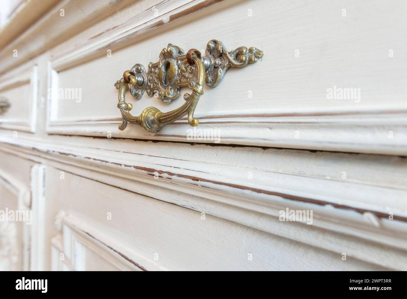 Poignée vintage en fer sur tiroir antique blanc, intérieur de la chambre de la maison, gros plan Banque D'Images