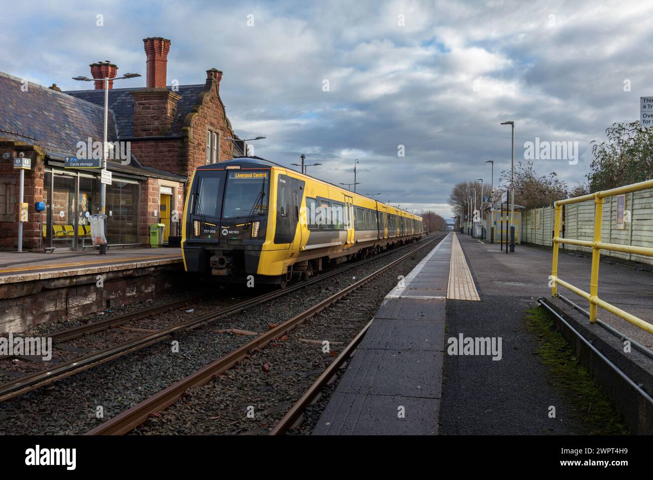 Merseyrail Stadler classe 777 train électrique 777006 à la gare Ellesmere Port, Cheshire, Royaume-Uni avec les bâtiments de la gare Banque D'Images