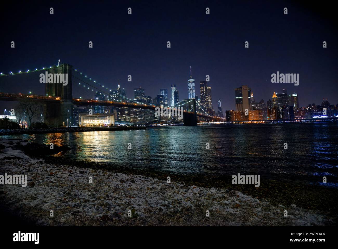 Horizon de Manhattan la nuit, lumières de la ville, Brooklyn Bridge et Manhattan Bridge de DUMBO pendant la saison des fêtes après la neige. Banque D'Images