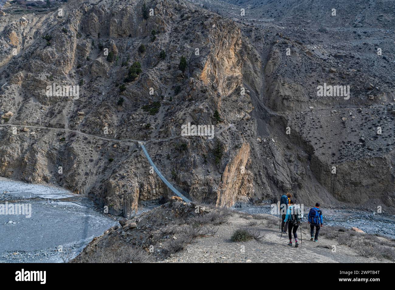 Touristes faisant une randonnée sur un immense pont suspendu, Royaume de Mustang, Népal Banque D'Images
