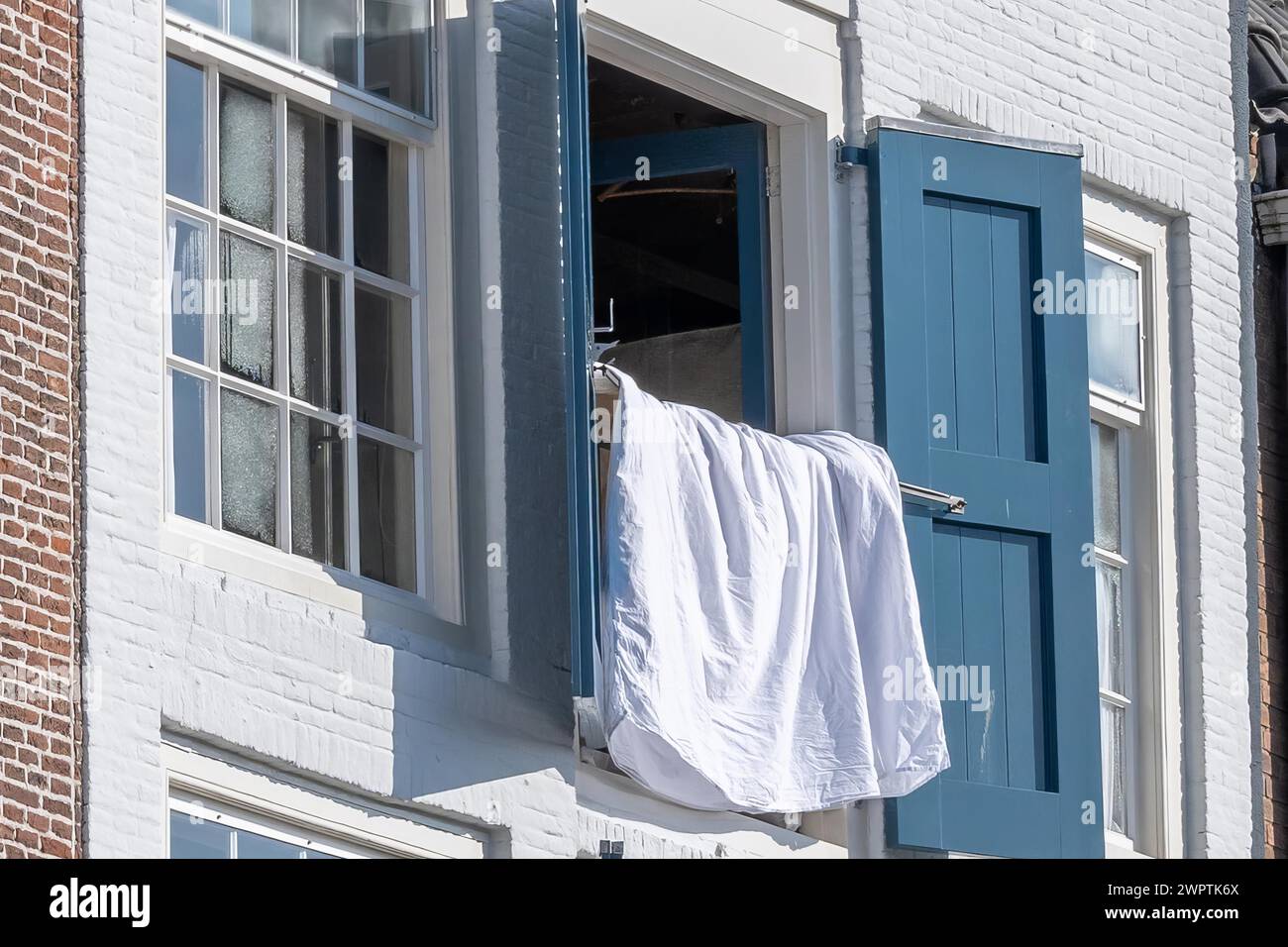 Gros plan d'une fenêtre ouverte avec des volets bleus et une chemise blanche, Middelburg, Zélande, pays-Bas Banque D'Images