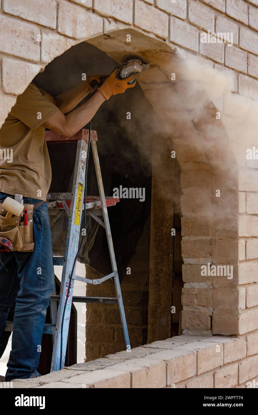 Un menuisier sur un escabeau meulant un cadre en briques adobe pour accueillir une fenêtre, dans un chantier près de la ville coloniale de Villa de Leyva. Banque D'Images
