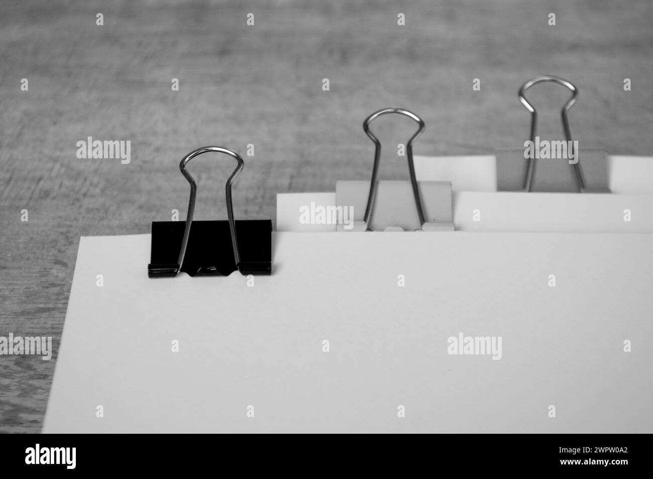 Papiers documents noir et blanc avec trombones pastel sur table en bois. Banque D'Images Papiers documents noir et blanc avec trombones pastel sur table en bois. Banque D'Images
