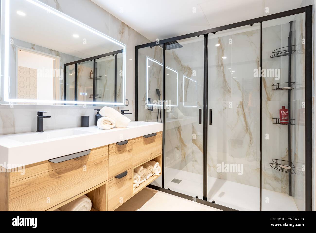 Une image en gros plan d'une salle de bain récemment rénovée avec des murs en marbre et une grande douche debout dans l'immobilier méditerranéen Banque D'Images