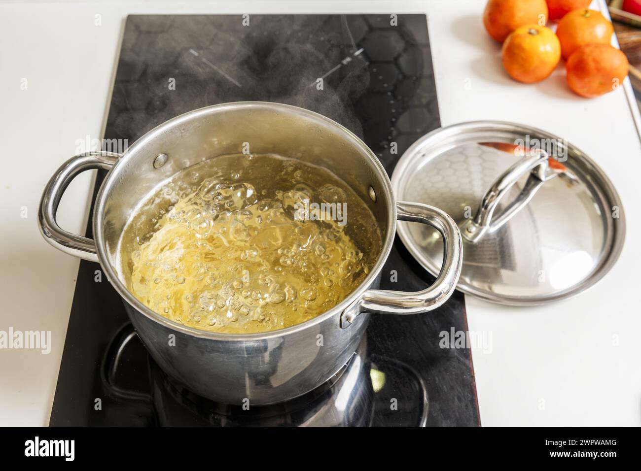 Une casserole en acier inoxydable remplie d'eau bouillante cuisant des pâtes al dente Banque D'Images