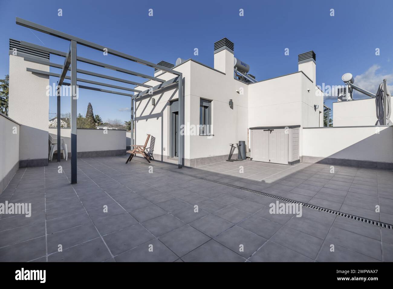 Grenier d'une maison unifamiliale avec sols clairs, auvent sans auvent, sol en grès gris sur une journée avec un ciel clair Banque D'Images