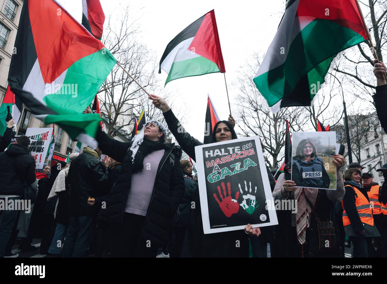 Paris, France. 09 mars 2024. Les manifestants avec des drapeaux palestiniens dont l'un tient une pancarte avec le message arrêtent le massacre à Gaza, pendant la manifestation. Manifestation de soutien au peuple palestinien pour exiger un cessez-le-feu, la fin des opérations militaires contre la bande de Gaza, la fin du conflit israélo-palestinien et la reconnaissance des droits du peuple palestinien, depuis la place de la République, le 9 mars 2024 à Paris. Photo de Christophe Michel/ABACAPRESS.COM crédit : Abaca Press/Alamy Live News Banque D'Images