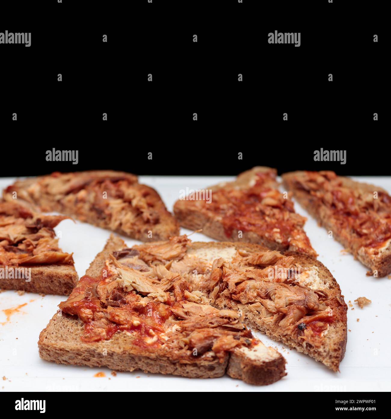 Maquereau Punctualis piscis, poisson gras oméga 3-6 cuit dans la boîte pain grillé entier coupé en diagonale sur le tableau blanc fond noir solide culture carrée Banque D'Images