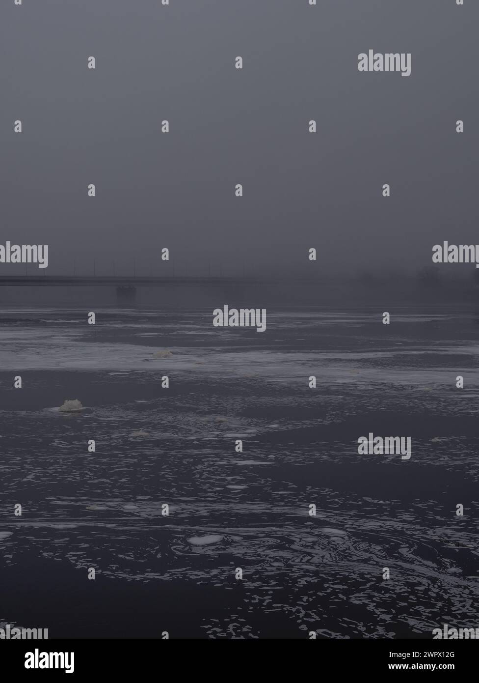 vue depuis la promenade sur un pont brumeux sur la rivière dauava 28.02.2024 Banque D'Images