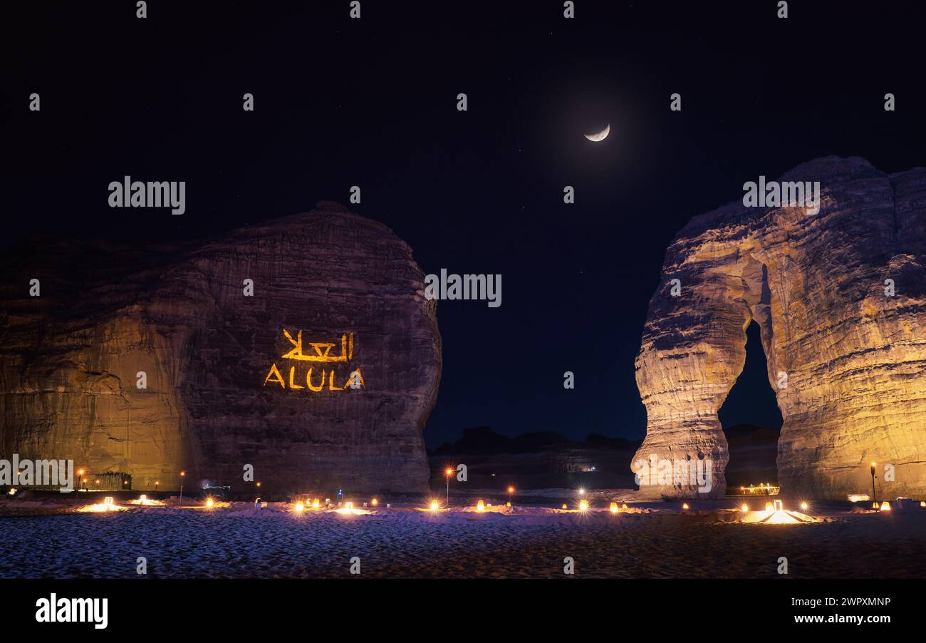 Jabal AlFil - Elephant Rock dans la soirée, paysage illuminé, texte Allula et traduction arabe projeté sur des sièges muraux en pierre pour les personnes installées sur le th Banque D'Images