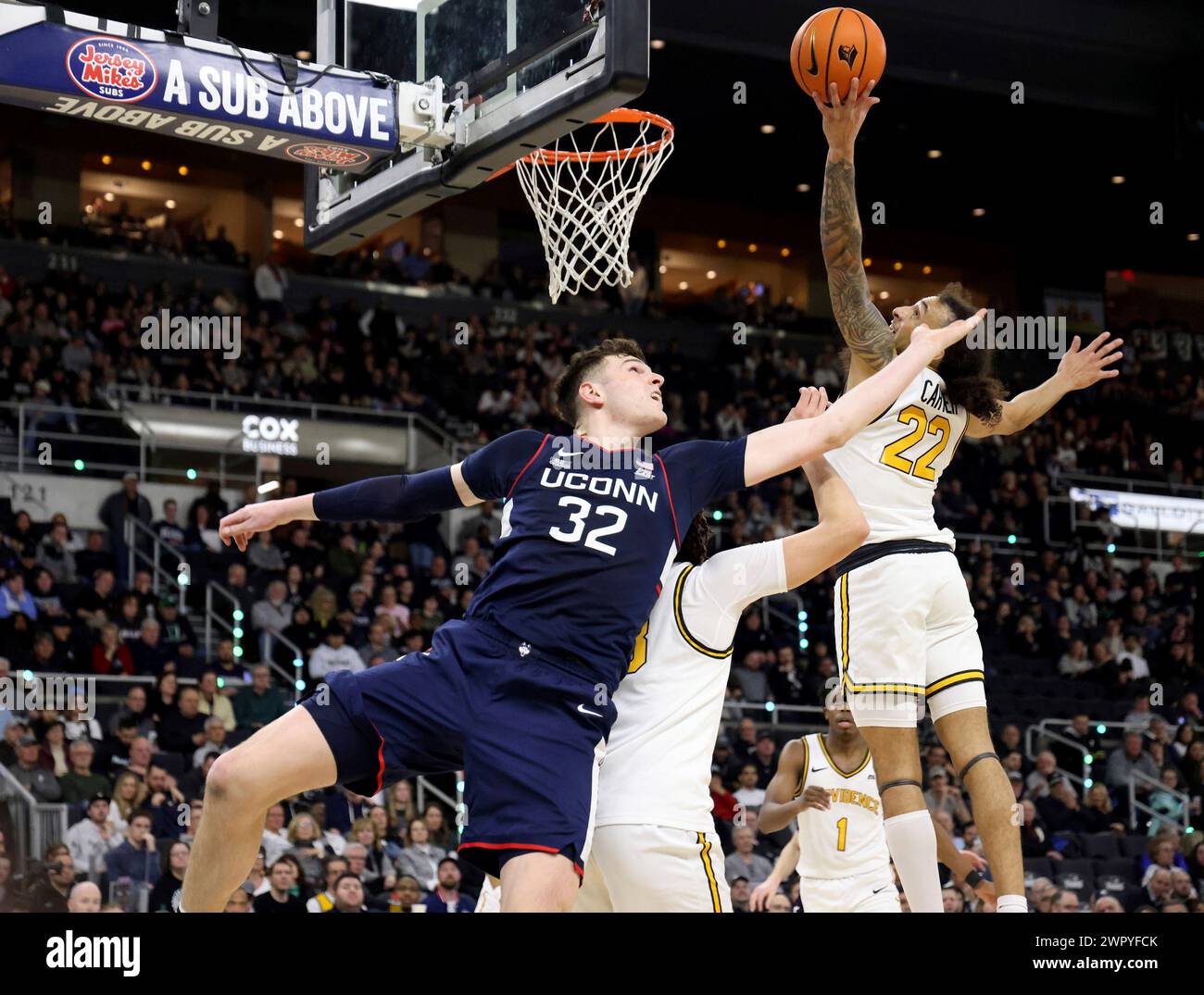 Providence guard Devin Carter (22) grabs a rebound as UConn center Donovan Clingan (32) defends during the second half of an NCAA college basketball game Saturday, March 9, 2024, in Providence, R.I. (AP Photo/Mark Stockwell) Banque D'Images