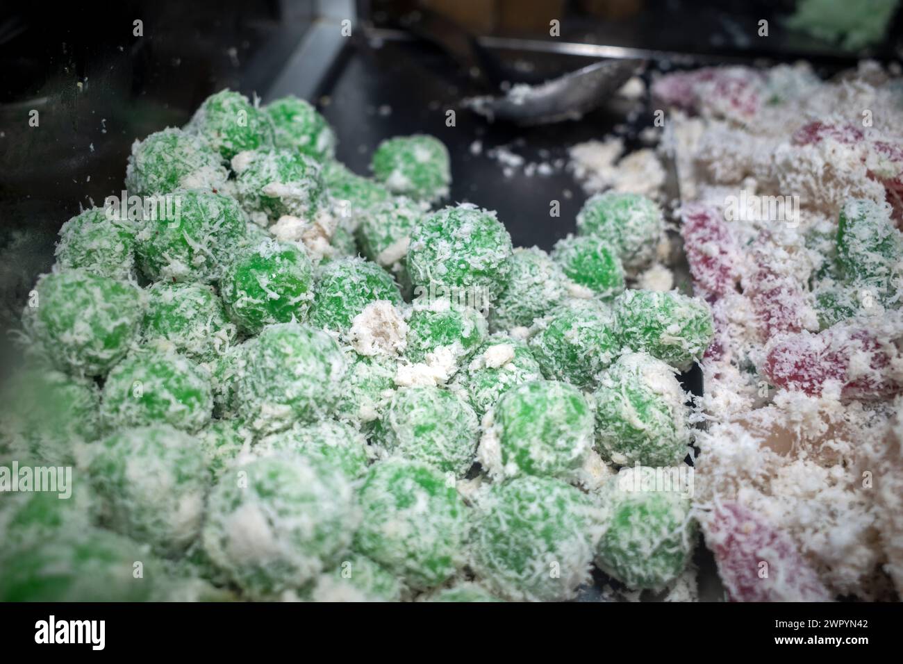 Kue Klepon, gâteau traditionnel indonésien à base de farine de riz gluante et fourré de sucre bruni recouvert de noix de coco râpée Banque D'Images