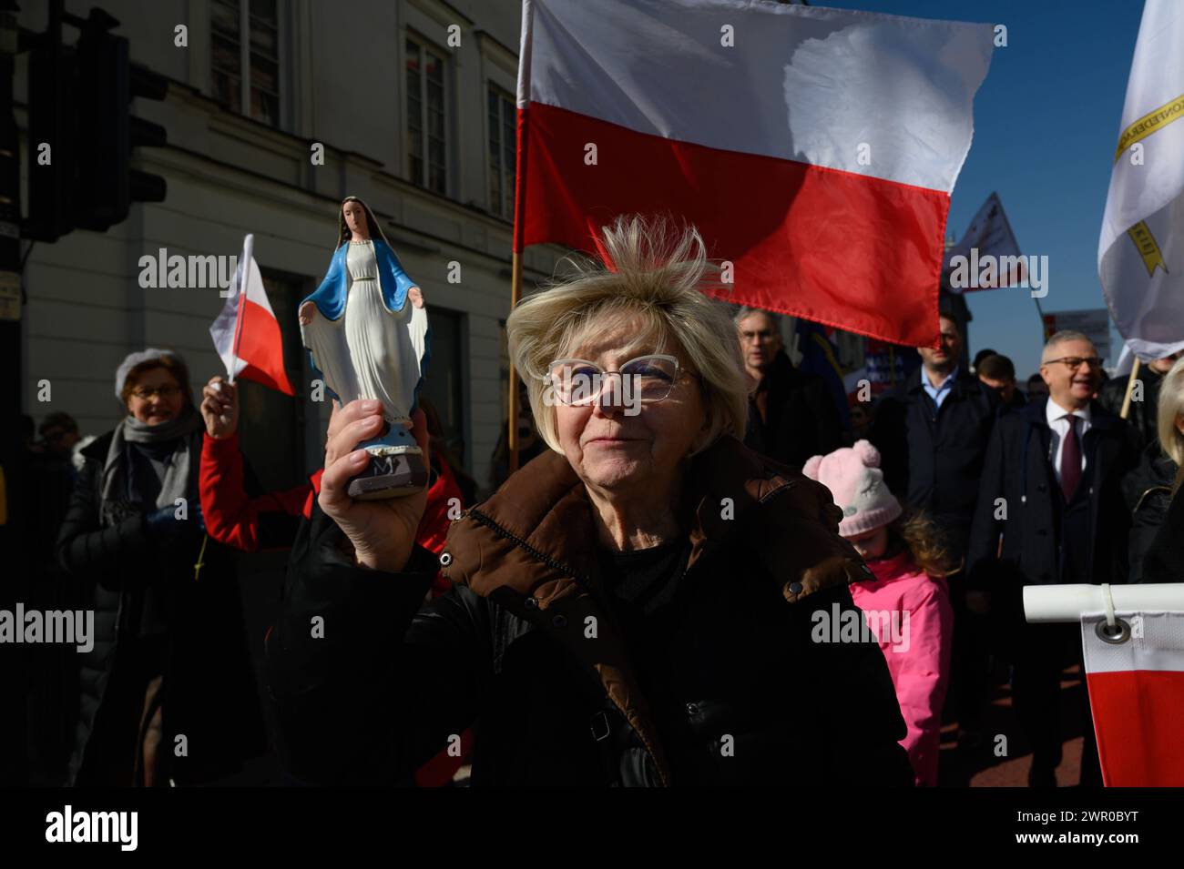 Manifestation Pologne pour la paix à Varsovie. Une femme porte une petite statue de la Vierge Marie lors d'une marche appelant à la paix et contre l'envoi de troupes polonaises en Ukraine à Varsovie, en Pologne, le 9 mars 2024. Quelques centaines de personnes sont descendues dans la rue après que le président français Emanuel Macron ait déclaré que le déploiement de troupes de l’OTAN en Ukraine ne devait pas être exclu. La foule, dirigée par les politiciens d'extrême droite Grzegorz Braun du parti de la Confédération Konfederacja, a crié des slogans comme des mains de nos enfants, Tusk, Kaczynski sur le front ukrainien et ce n'est pas notre guerre . Varsovie Pologne Copyright : XAL Banque D'Images