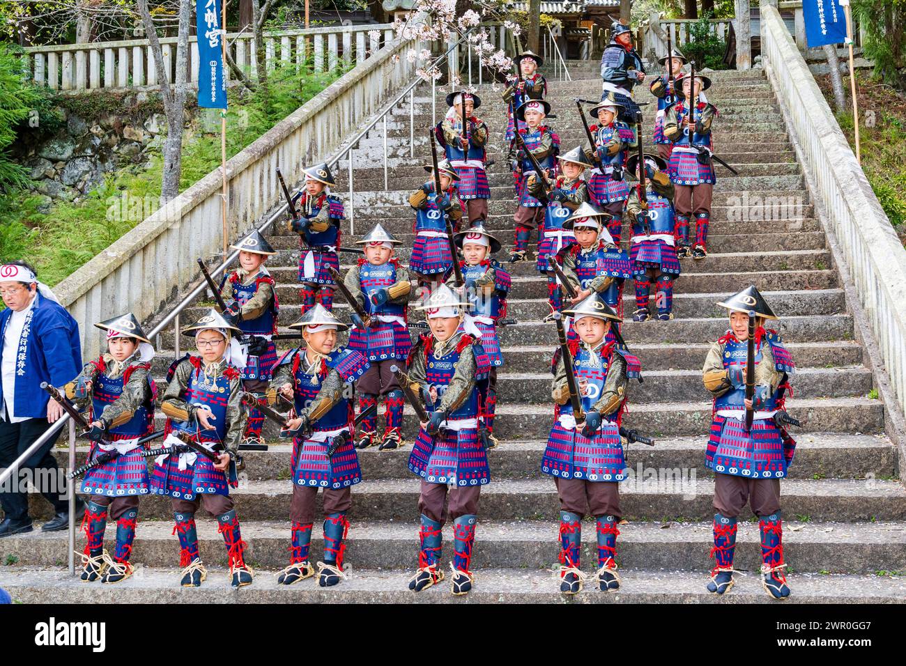 Des enfants japonais habillés en soldats Teppou ashigaru debout sur des marches de pierre tirant leurs armes à allumettes pendant la parade des samouraïs à Tatsuno Banque D'Images