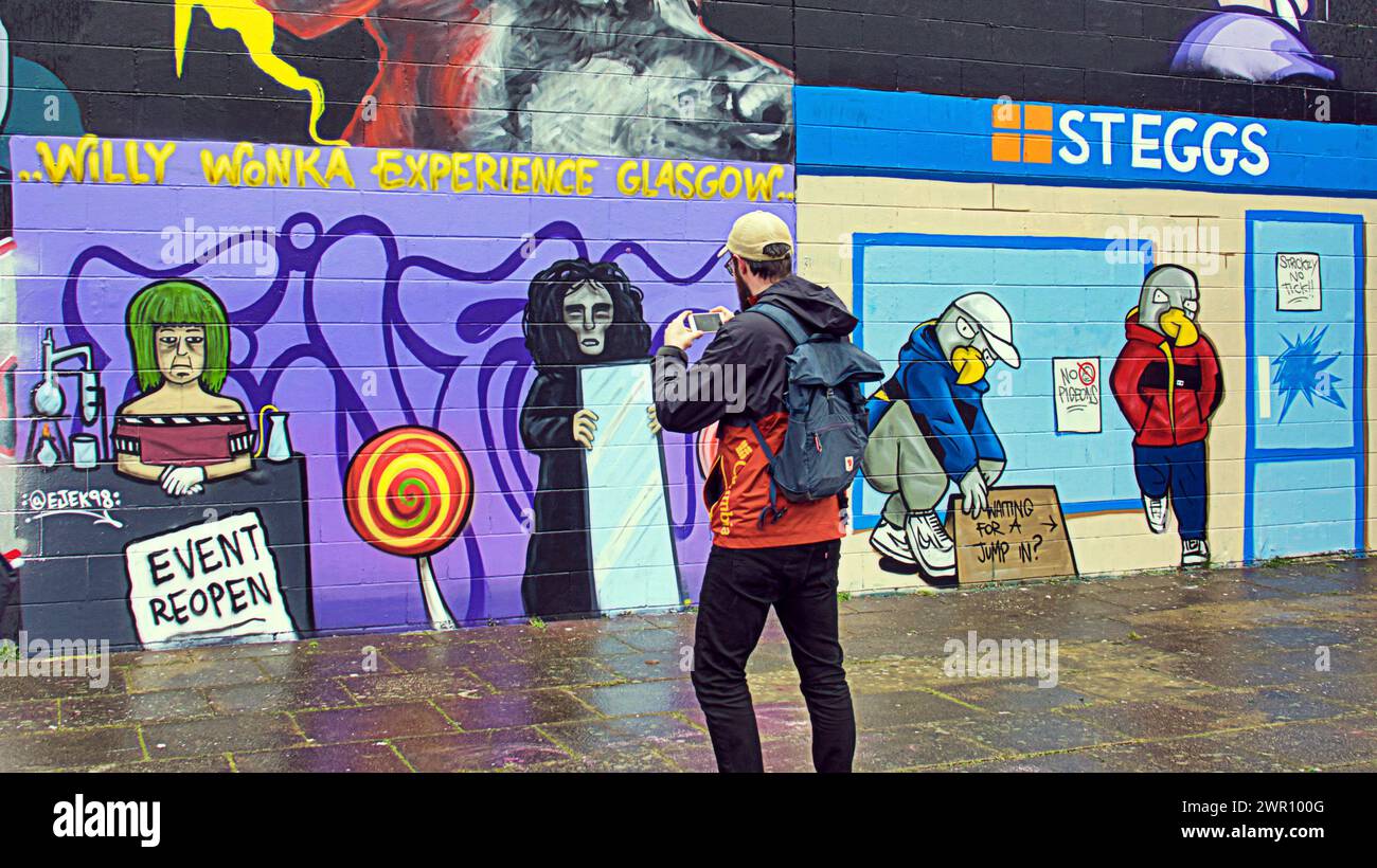 Glasgow, Écosse, Royaume-Uni. 10 mars 2024 : les fans sont descendus à l'œuvre d'art sur les rives de la rivière clyde. La fresque murale de la débâcle de Willy Wonka est apparue sur le mur de graffiti côté clyde sur la passerelle clyde. La peinture a été créée par l'artiste Ejek après que l'événement film Experience est devenu l'actualité nationale. L'œuvre représente les actrices qui ont travaillé à l'événement en tant qu'Oompa Loompa et 'The Unknown' du script d'intelligence artificielle. Crédit Gerard Ferry/Alamy Live News Banque D'Images
