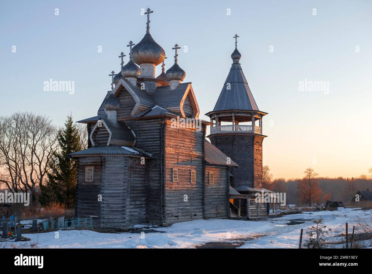 L'ancienne église en bois de Dmitry Solunsky sur fond de coucher du soleil d'avril. Shcheleyki. Oblast de Leningrad, Russie Banque D'Images