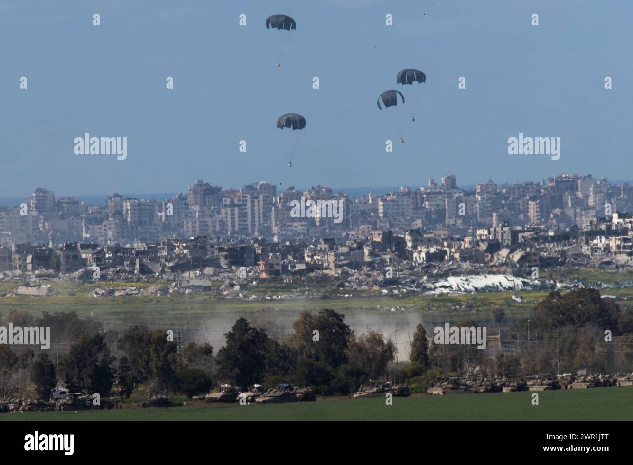 Sud d'Israël, Israël. 10 mars 2024. Ce que l'on pense être un C-130 de l'armée de l'air américaine lâche de l'aide humanitaire en parachute au-dessus du nord de la bande de Gaza vu de l'intérieur du sud d'Israël le 10 mars 2024. Les États-Unis et d'autres pays continuent de distribuer de la nourriture et d'autres fournitures d'aide humanitaire aux Palestiniens dans le besoin dans la bande de Gaza juste avant le début du mois sacré islamique du Ramadan alors que la guerre d'Israël contre le Hamas se poursuit. Photo de Jim Hollander/UPI crédit : UPI/Alamy Live News Banque D'Images