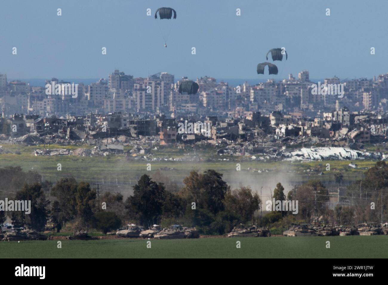 Sud d'Israël, Israël. 10 mars 2024. Ce que l'on pense être un C-130 de l'armée de l'air américaine lâche de l'aide humanitaire en parachute au-dessus du nord de la bande de Gaza vu de l'intérieur du sud d'Israël le 10 mars 2024. Les États-Unis et d'autres pays continuent de distribuer de la nourriture et d'autres fournitures d'aide humanitaire aux Palestiniens dans le besoin dans la bande de Gaza juste avant le début du mois sacré islamique du Ramadan alors que la guerre d'Israël contre le Hamas se poursuit. Photo de Jim Hollander/UPI crédit : UPI/Alamy Live News Banque D'Images