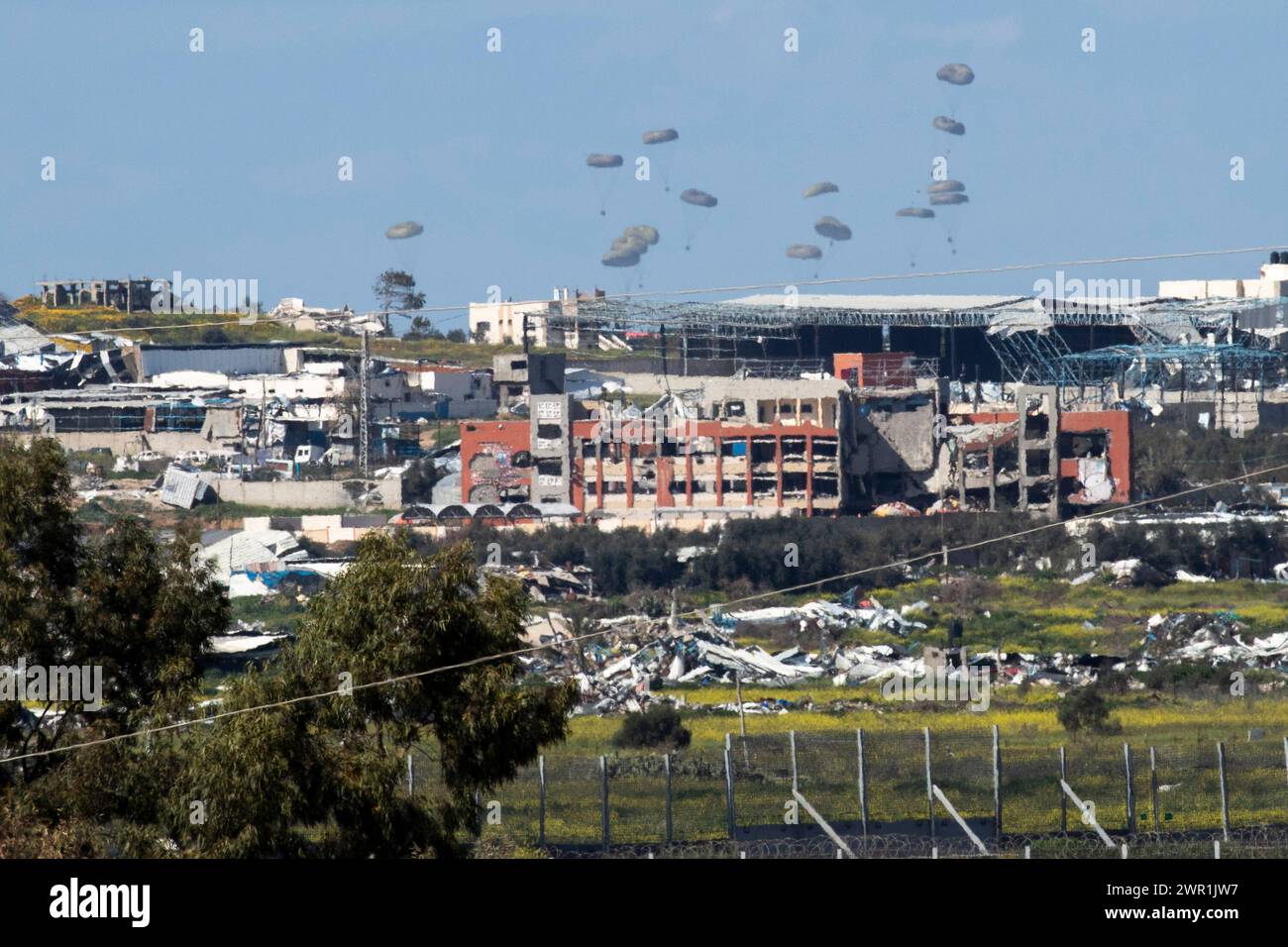 Sud d'Israël, Israël. 10 mars 2024. Ce que l'on pense être un C-130 de l'armée de l'air américaine lâche de l'aide humanitaire en parachute au-dessus du nord de la bande de Gaza vu de l'intérieur du sud d'Israël le 10 mars 2024. Les États-Unis et d'autres pays continuent de distribuer de la nourriture et d'autres fournitures d'aide humanitaire aux Palestiniens dans le besoin dans la bande de Gaza juste avant le début du mois sacré islamique du Ramadan alors que la guerre d'Israël contre le Hamas se poursuit. Photo de Jim Hollander/UPI crédit : UPI/Alamy Live News Banque D'Images