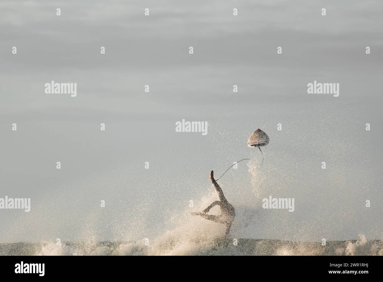 Vue d'un surfeur perdant sa planche de surf en essayant de surfer sur une vague Banque D'Images