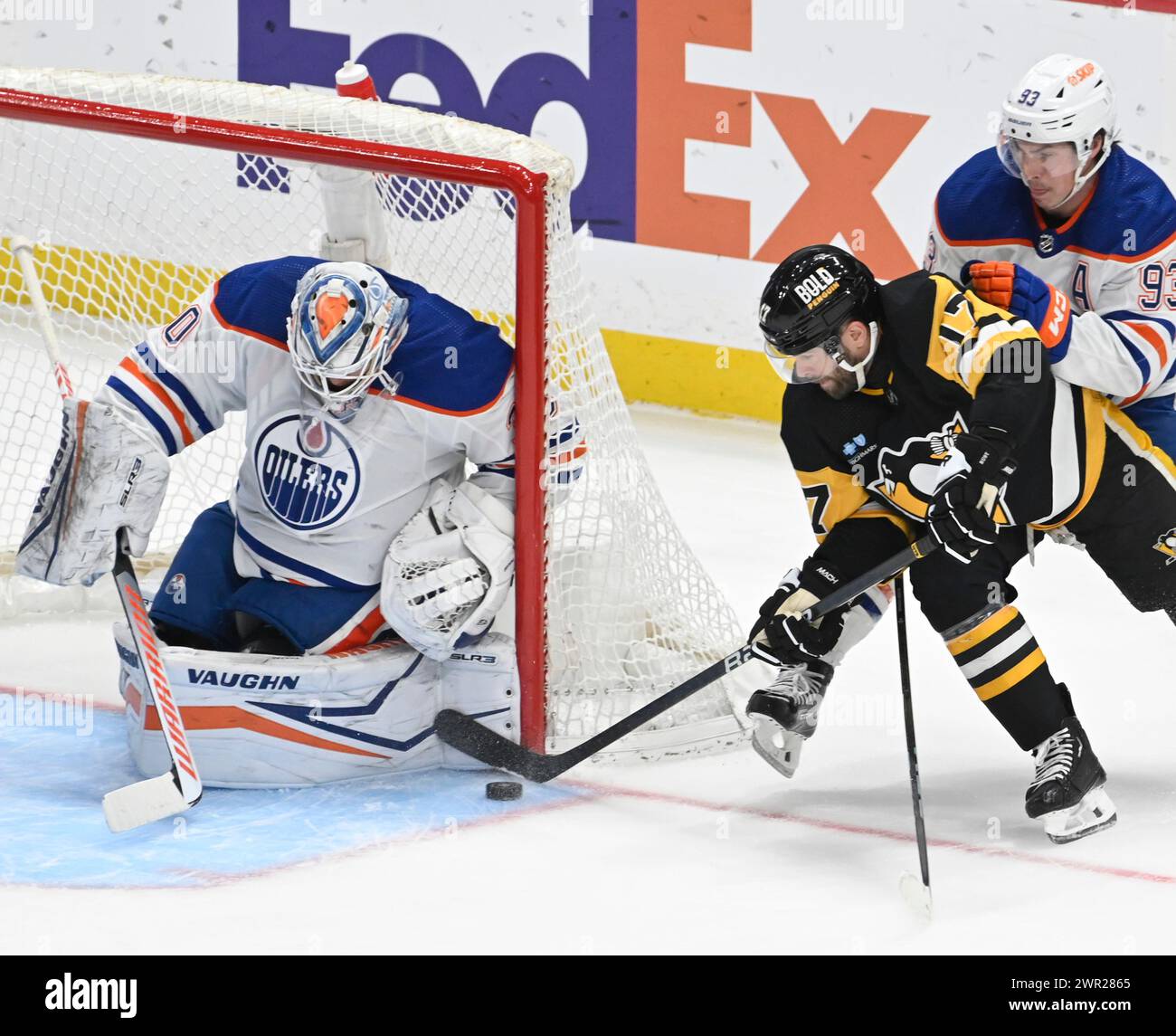 Pittsburgh, États-Unis. 10 mars 2024. Calvin Pickard (30), gardien des Oilers d'Edmonton, bloque le coin du but alors que Bryan Rust (17), aile droite des Penguins de Pittsburgh, patine derrière le filet, le centre des Oilers d'Edmonton, Ryan Nugent-Hopkins (93), jouant en première période contre les Penguins de Pittsburgh au PPG Paints Arena de Pittsburgh, en Ontario dimanche 10 mars 2024. Photo par Archie Carpenter/UPI. Crédit : UPI/Alamy Live News Banque D'Images