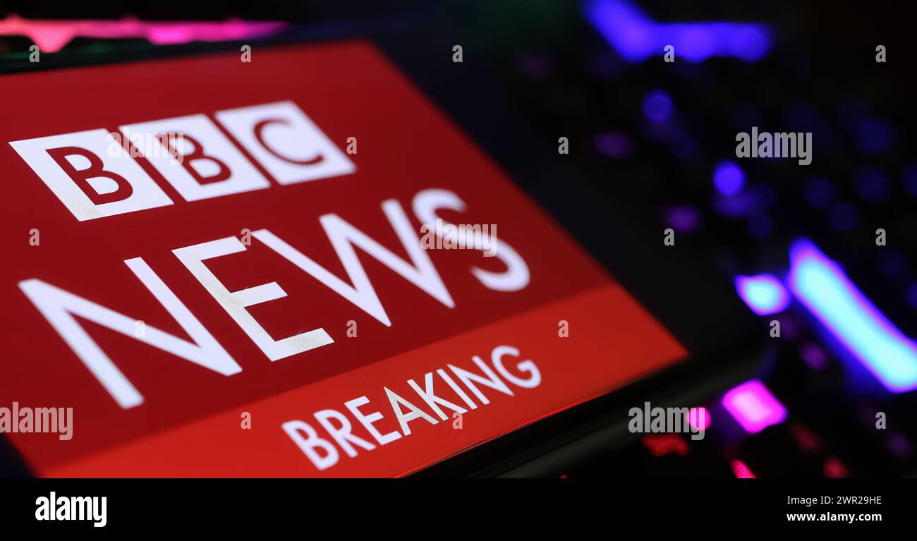 Viersen, Allemagne - 1er mars. 2024 : gros plan de smartphone avec lettrage logo de BBC Breaking News sur clavier d'ordinateur Banque D'Images