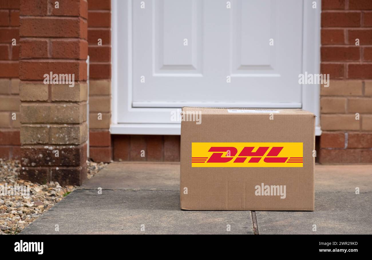 Exeter, UK-10 mars 2024 : une boîte de livraison DHL devant une porte. DHL est une société de logistique allemande qui fournit des services de messagerie, de livraison de colis et de courrier Banque D'Images