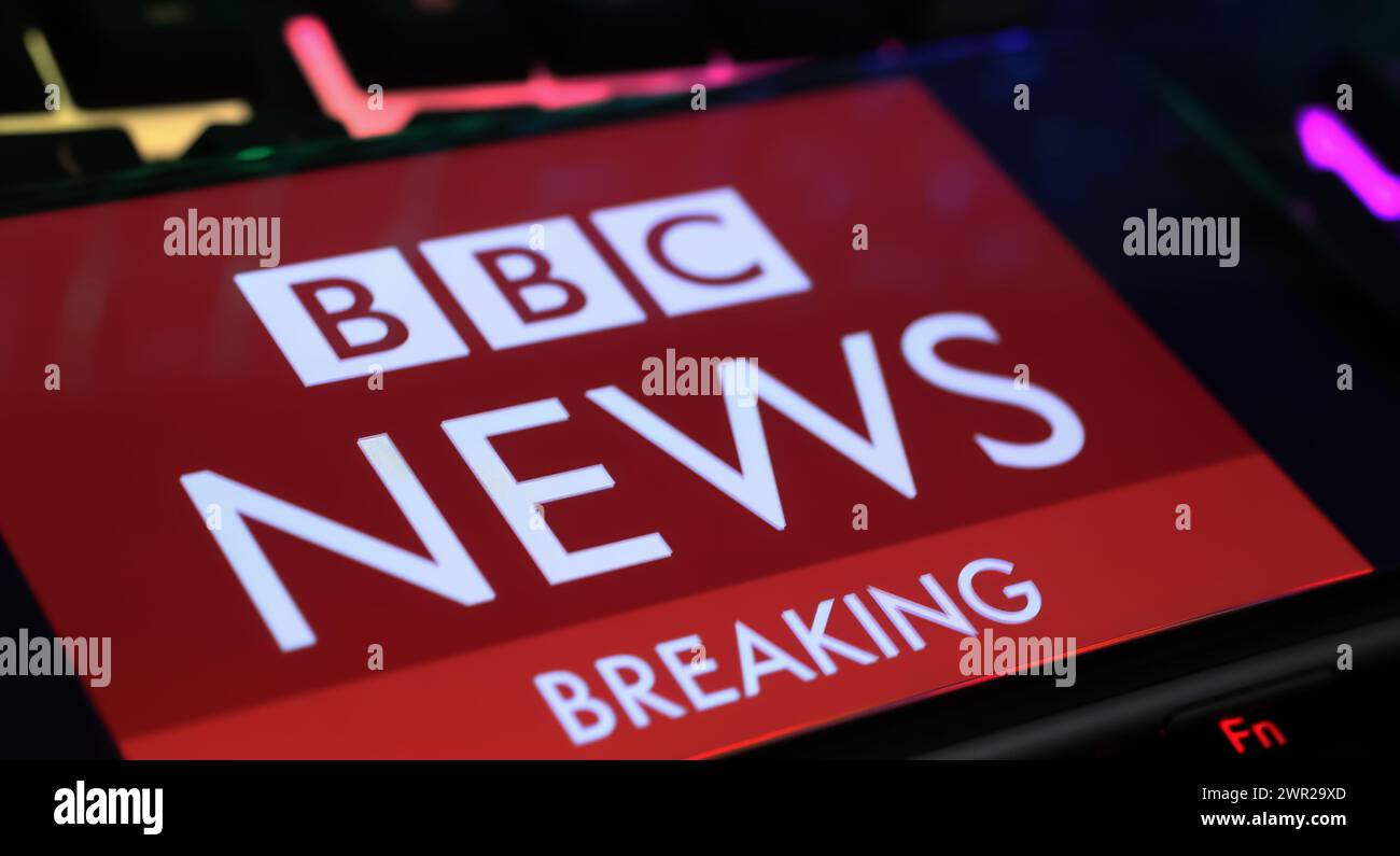 Viersen, Allemagne - 1er mars. 2024 : gros plan de smartphone avec lettrage logo de BBC Breaking News sur clavier d'ordinateur Banque D'Images