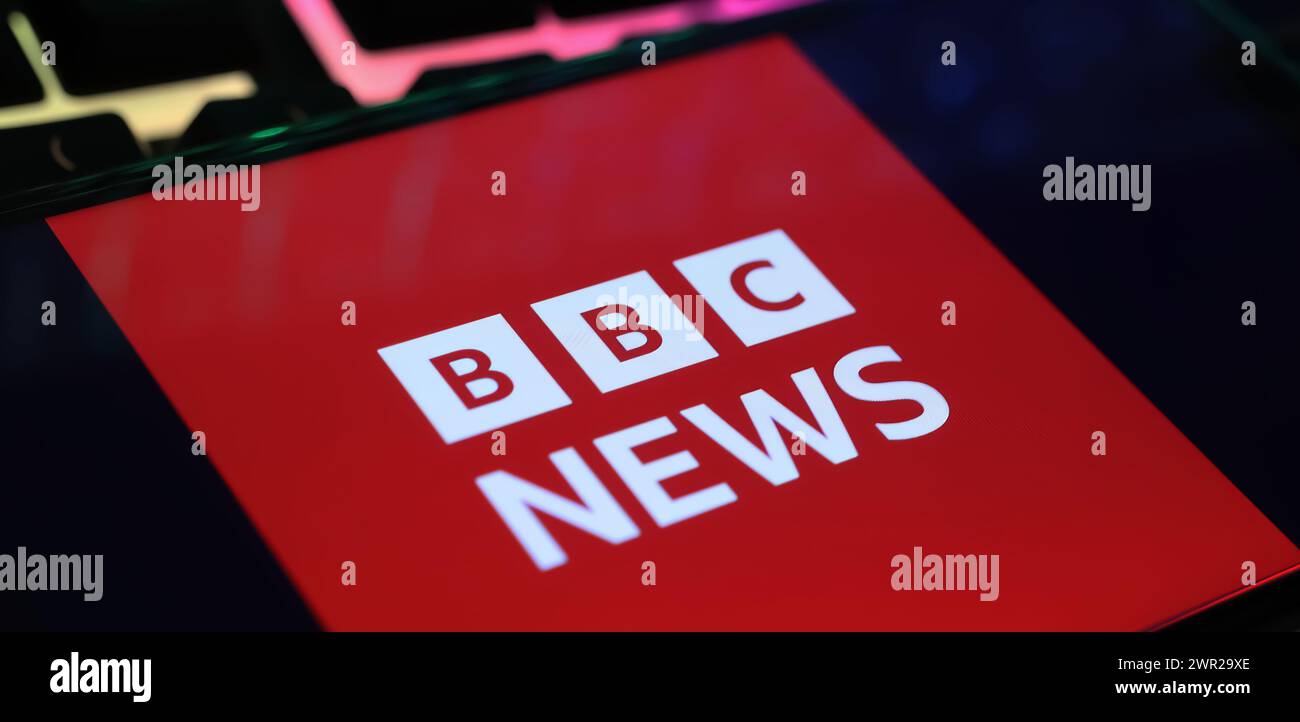 Viersen, Allemagne - 1er mars. 2024 : gros plan de smartphone avec lettrage logo de BBC Breaking News sur clavier d'ordinateur Banque D'Images