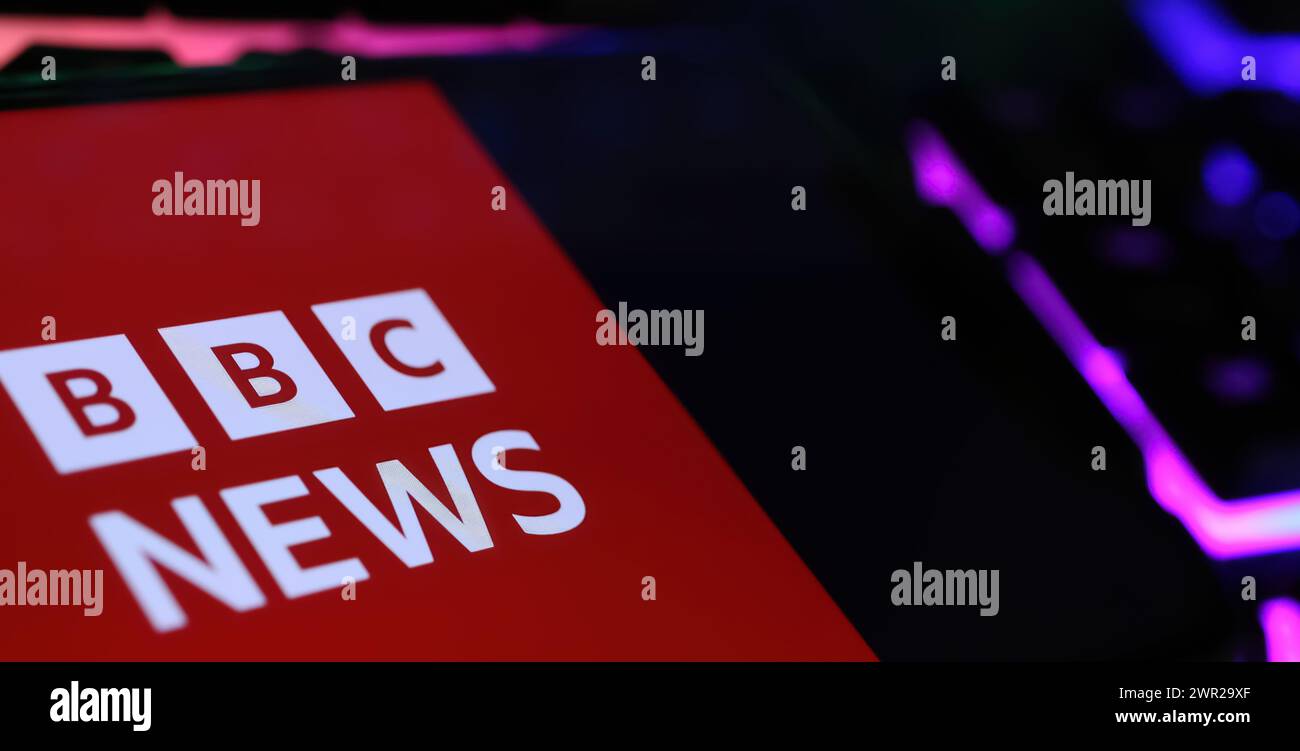 Viersen, Allemagne - 1er mars. 2024 : gros plan de smartphone avec lettrage logo de BBC Breaking News sur clavier d'ordinateur Banque D'Images